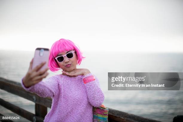 young woman with pink hair taking a selfie - morro fotografías e imágenes de stock