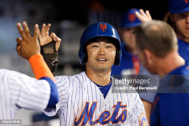 Norichika Aoki of the New York Mets celebrates with teammates in the dugout after scoring a run on a ball hit by Asdrubal Cabrera during the fifth...