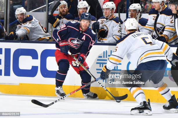 Boone Jenner of the Columbus Blue Jackets skates with the puck as Matt Tennyson of the Buffalo Sabres defends during the first period of a game on...