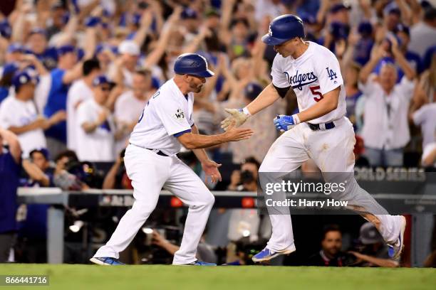 Corey Seager of the Los Angeles Dodgers celebrates with third base coach Chris Woodward after hitting a two-run home run during the sixth inning...
