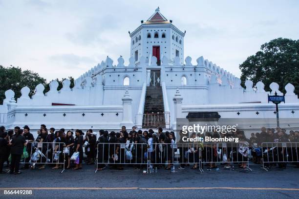 Mourners stand in line to enter Sanam Luang park, where the Royal Crematorium is located, ahead of the cremation of the late King Bhumibol Adulyadej...