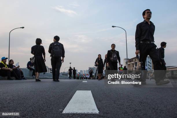 Thai mourners walk across a bridge near the Royal Crematorium ahead of the cremation of the late King Bhumibol Adulyadej in Bangkok, Thailand, on...