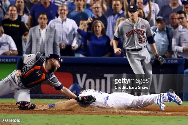 Logan Forsythe of the Los Angeles Dodgers scores a run on a RBI single hit by Enrique Hernandez to tie the game 5-5 during the tenth inning against...