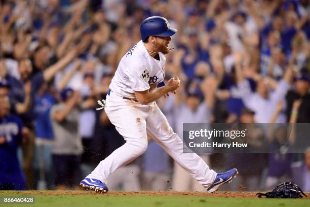 Logan Forsythe of the Los Angeles Dodgers celebrates scoring a run on a RBI single hit by Enrique Hernandez to tie the game 5-5 during the tenth...