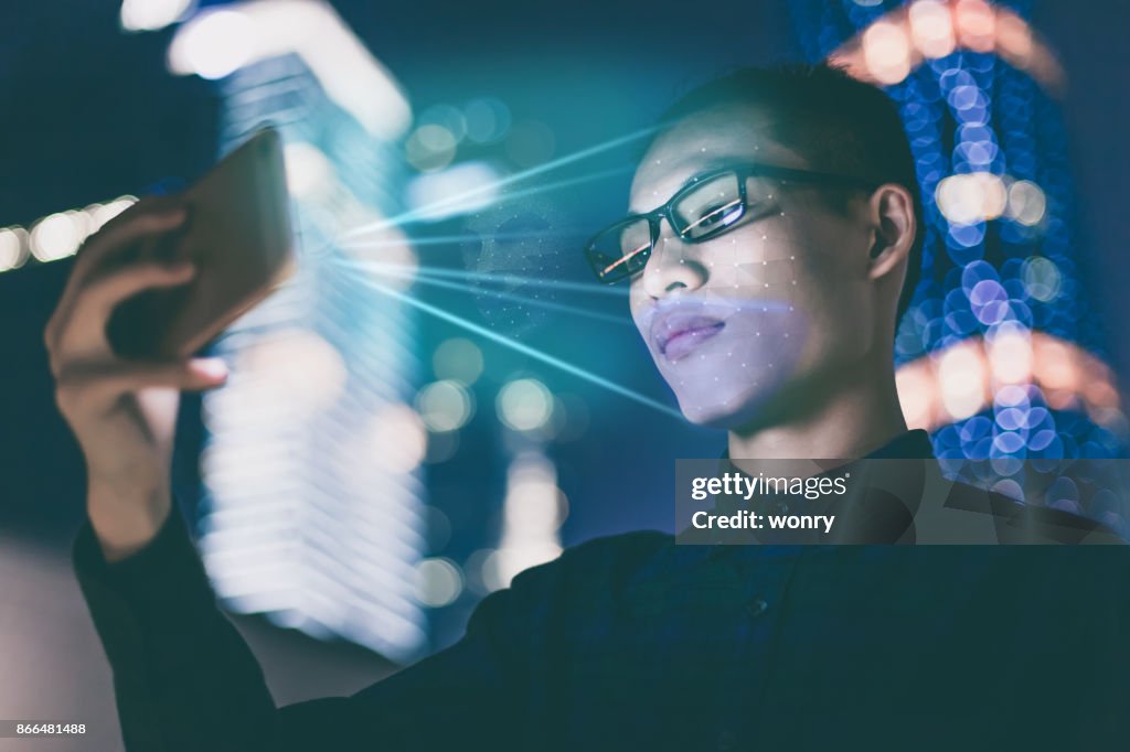 Businessman using using face recognition outdoors