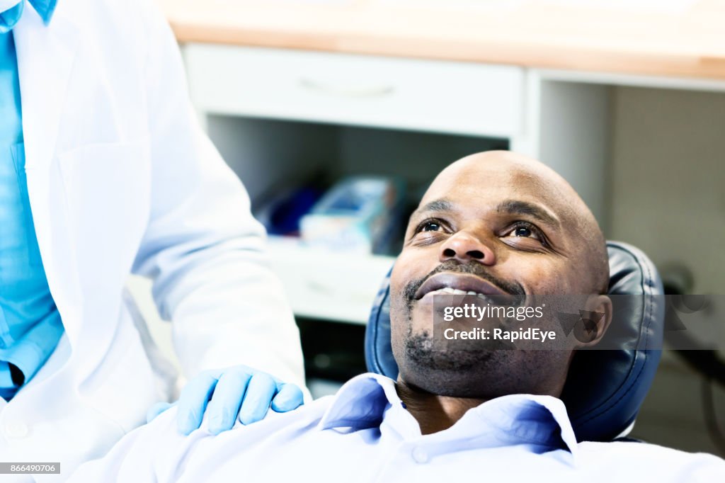 Happy dental patient smiles up at unseen dentist