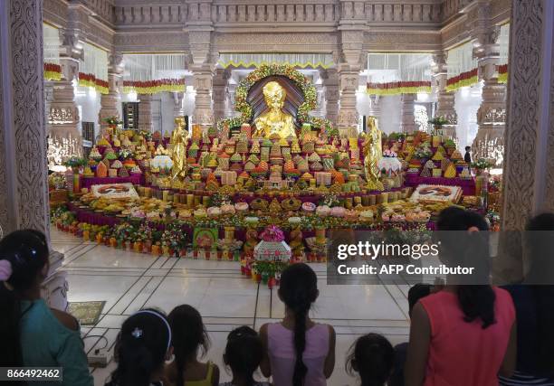 Devotees admire an Annakut, or "mountain of food", on the occasion of Labh Pancham at the end of the Diwali celebrations in front of an idol of the...