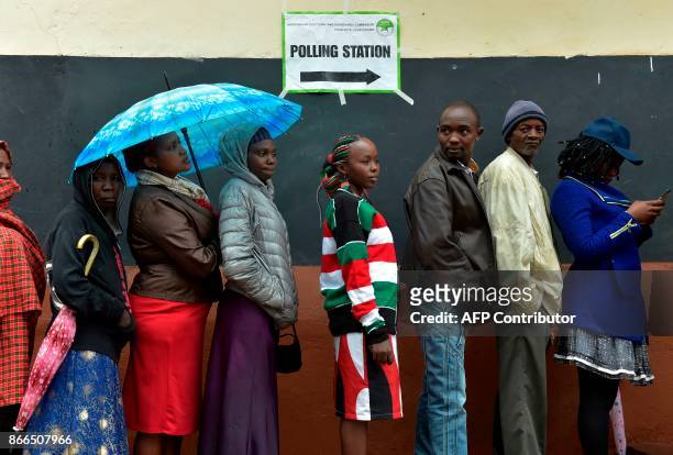 Voters queue at a polling station at Mutomo primary school in Kiambu on October 26 as polls opened for presidential elections. Kenyans began voting...