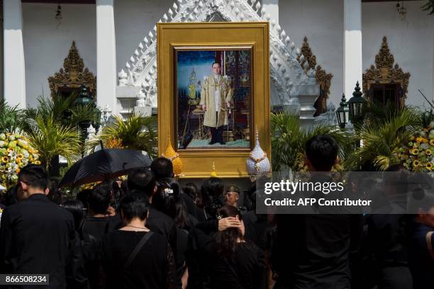 Mourners prepare to lay flowers as a sign of respect for the late Thai king Bhumibol Adulyadej in Bangkok on October 26, 2017. A sea of black-clad...