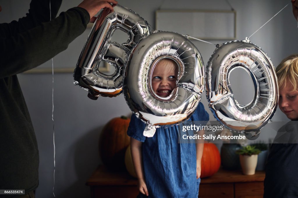 Child peering through a boo sign