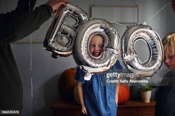 child peering through a boo sign - silver balloon imagens e fotografias de stock