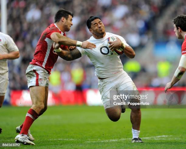 Manu Tuilagi of England forces his way past Mike Phillips of Wales during an RBS 6 Nations match at Twickenham Stadium on February 25, 2012 in...