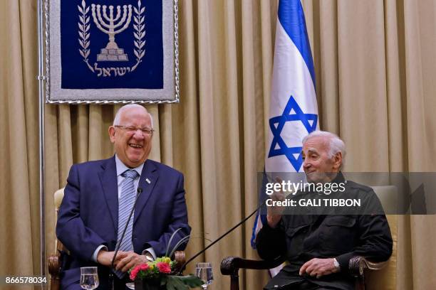 Israeli President Reuven Rivlin laughs as French-Armenian singer Charles Aznavour speaks on October 26, 2017 at the presidential compound in...