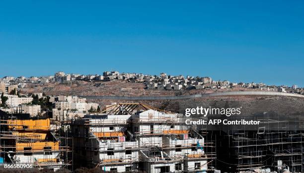 Buildings are seen under construction in the Israeli settlement of Pisgat Zeev in front of the Israeli barrier separating Jerusalem to the West Bank...