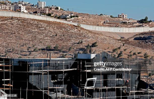 Buildings are seen under construction in the Israeli settlement of Pisgat Zeev in front of the Israeli barrier separating Jerusalem to the West Bank...