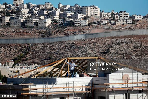 Buildings are seen under construction in the Israeli settlement of Pisgat Zeev in front of the Israeli barrier separating Jerusalem to the West Bank...
