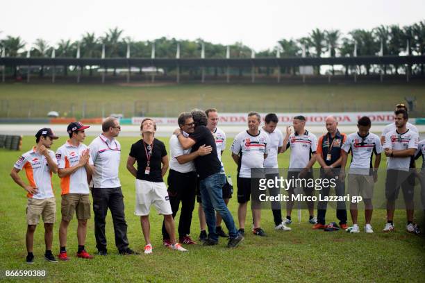 Paolo Simoncelli of Italy hugs Carlo Fiorani of Italy and HRC Communications Director during the "Track walk to Turn 11 for SIC " ahead of the MotoGP...