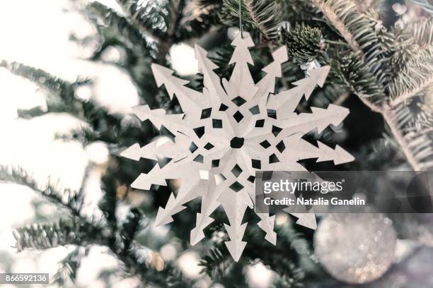 paper snowflake hanging on christmas tree - paper snowflakes stock-fotos und bilder