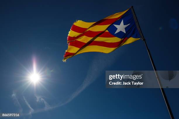 The sun shines on a Catalan independence flag as it flutters in the wind on the top of a cliff on October 24, 2017 in Ulldemolins, Spain. Catalonia...