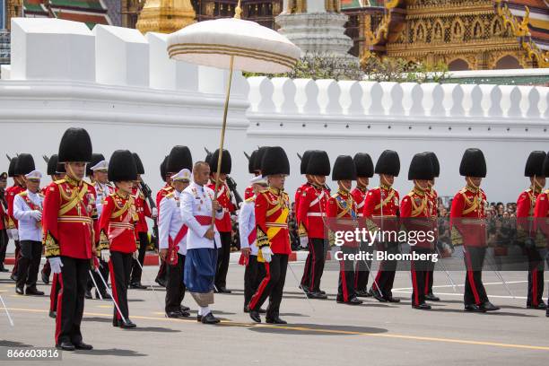 Thai King Maha Vajiralongkorn, center, walks under a parasol during the cremation procession for the late King Bhumibol Adulyadej at Sanam Luang...