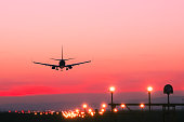 Plane lands at an airfield at the sunset