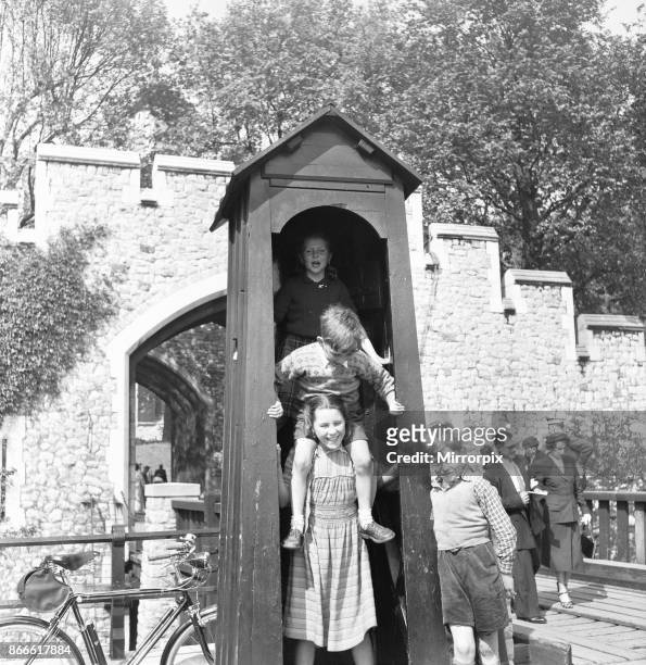 When the sentry is away the children will play. Children visiting The Tower of London play in a empty sentry box at the entrance to the tower, 2nd...