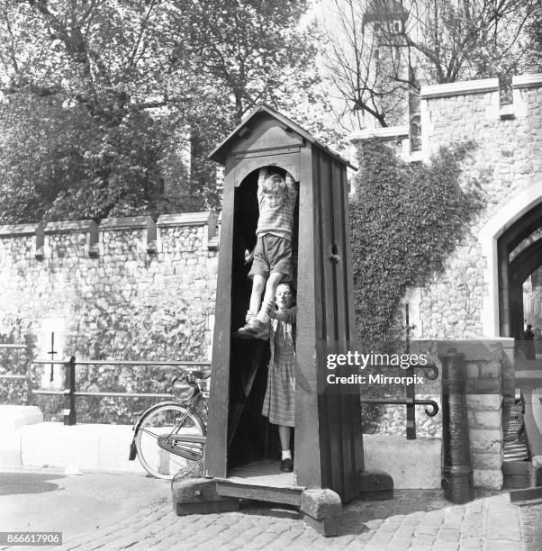 When the sentry is away the children will play. Children visiting The Tower of London play in a empty sentry box at the entrance to the tower, 2nd...