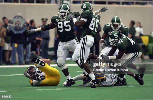 Defensive tackle Josh Shaw and linebacker Ivory McCoy of the Michigan State Spartans celebrate after nailing wide receiver Chris Oliver of the Iowa...