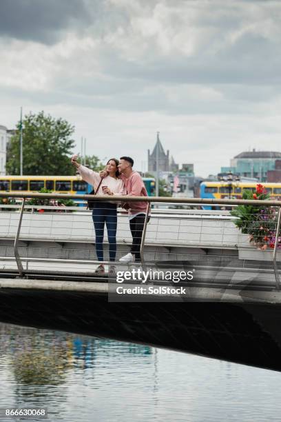 young couple on bench in dublin - dublin stock pictures, royalty-free photos & images