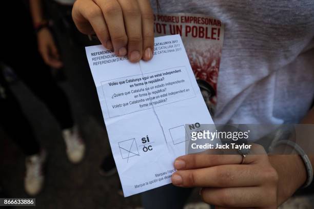 Protester holds a torn ballot paper marked 'si' for yes from the October 1st Catalan independence referendum during a pro-independence strike of...