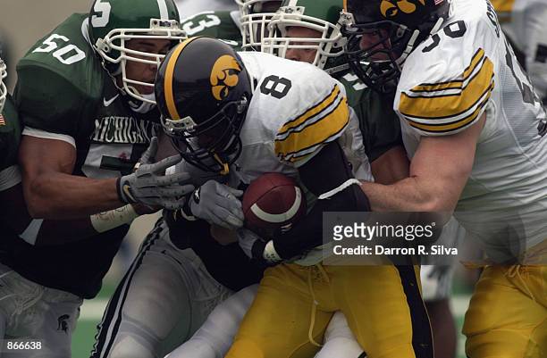 Wide receiver CJ Jones of the Iowa Hawkeyes pushes for extra yardage against linebacker Josh Thornhill of the Michigan State Spartans during the Big...