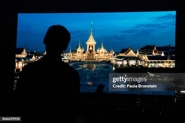 Thai mourners watch a big screen during a religious ceremony on the day of the historical cremation of Thailand's King Bhumibol on October 26,...