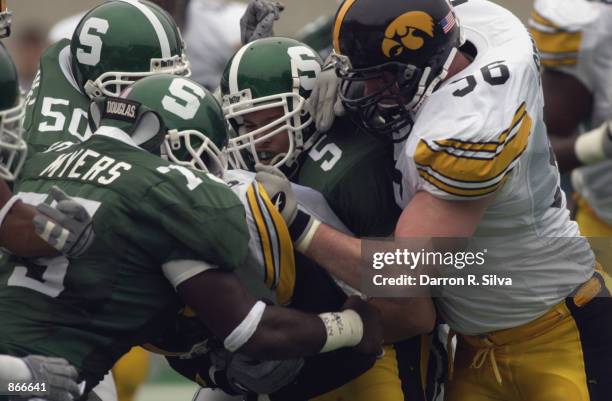 Defensive end Nick Myers, linebacker Josh Thornhill and safety Lorenzo Guess of the Michigan State Spartans sandwich wide receiver CJ Jones of the...