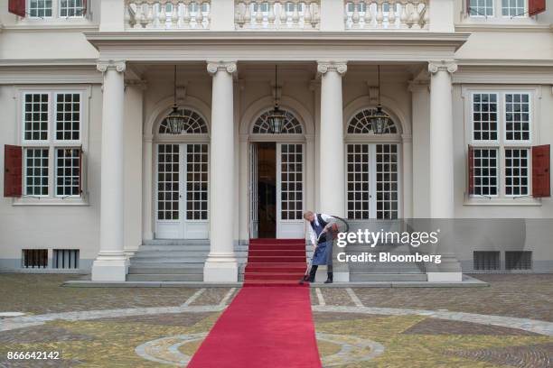 Worker vacuums the red carpet outside the Noordeinde Palace in The Hague, Netherlands, on Thursday, Oct. 26, 2017. King Willem-Alexander of the...