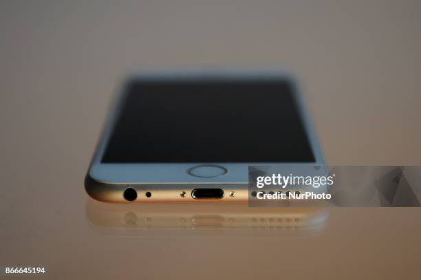 The Lightning port and headphone jack on the bottom of an iPhone 6 are seen on a glass table on October 25, 2017.