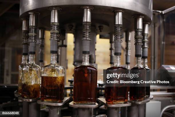 bottles of single barrel bourbon are filled on the bottling line at a distillery - bourbon whisky stockfoto's en -beelden