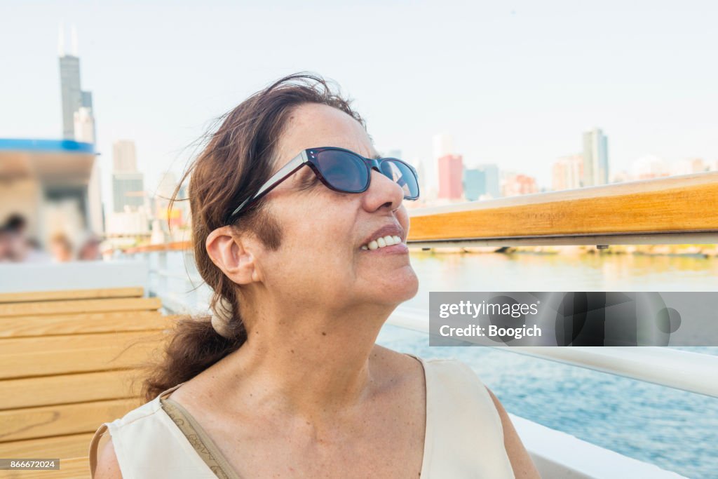 Smiling Senior Hispanic Woman by Chicago Skyline Enjoying Tour