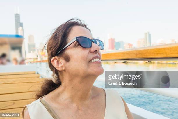 smiling senior hispanic woman by chicago skyline enjoying tour - hot puerto rican women stock pictures, royalty-free photos & images