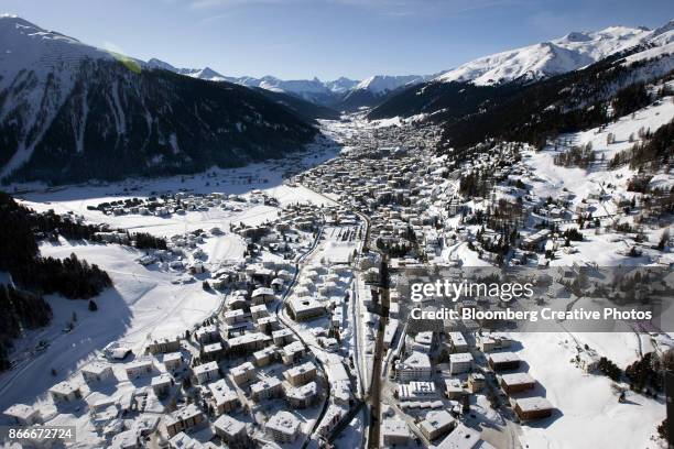 snow-covered rooftops of davos town - davos stock-fotos und bilder