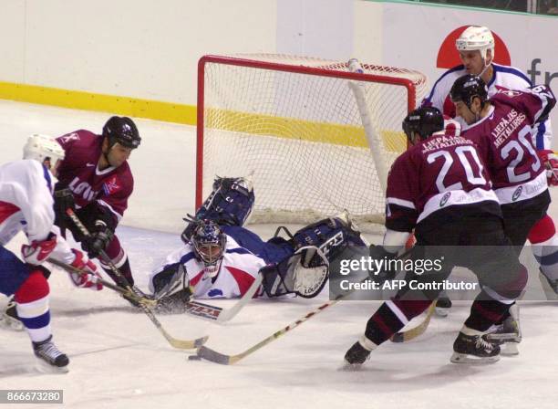 Le gardien de but français Christobal Huet plonge pour stopper la palet face à l'attaquant letton, Haris Vitolins , le 09 novembre 2001 à Grenoble,...