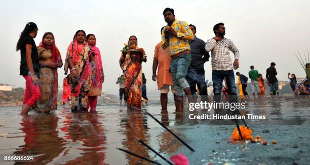 Devotees offer prayers on the bank of river Tawi during sunset to mark Chhath Puja festival, on October 26, 2017 in Jammu, India. Thousands of...