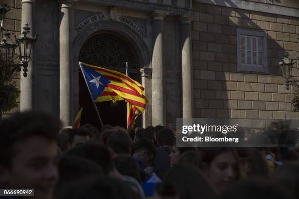 Students wave a Catalan pro-independence flag outside the Generalitat regional government offices at Sant Jaume after a demonstration protesting the...