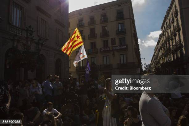 Students wave a Catalan pro-independence flag outside the Generalitat regional government offices at Sant Jaume after a demonstration protesting the...