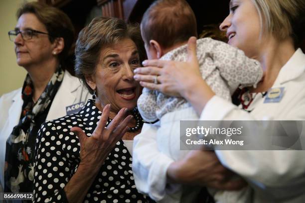 Rep. Jan Schakowsky plays with three-month-old Zadie Miller as her mother Sarah Horvath , an MD with Physicians for Reproductive Health, looks on...