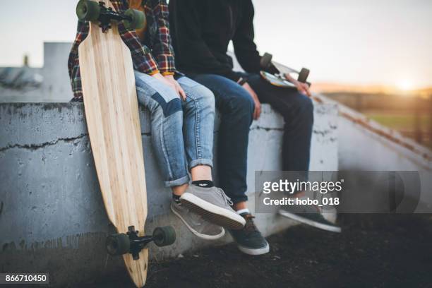 skateboarders taking a rest in skate park - couple skating stock pictures, royalty-free photos & images