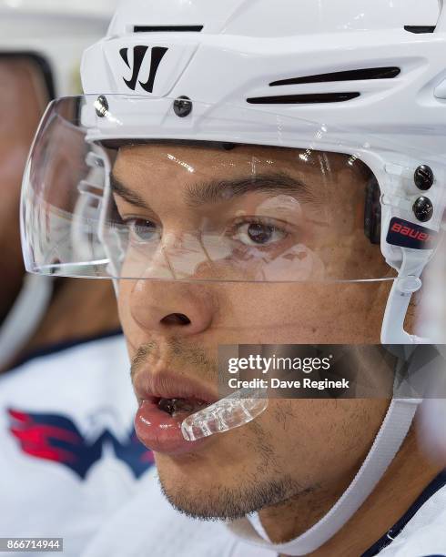 Madison Bowey of the Washington Capitals watches the action from the bench against the Detroit Red Wings during an NHL game at Little Caesars Arena...