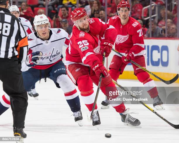 Mike Green of the Detroit Red Wings passes the puck in front of T.J. Oshie of the Washington Capitals during an NHL game at Little Caesars Arena on...