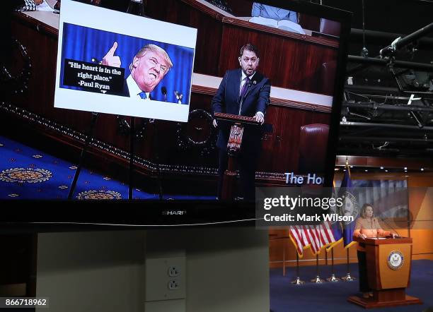 Live CSPAN feed from the House Chamber plays on a monitor as House Minority Leader Nancy Pelosi speaks to the media during her weekly news conference...