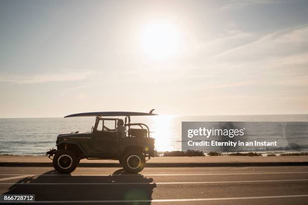 mature man sitting in his land cruiser by the beach - 4x4 photos et images de collection