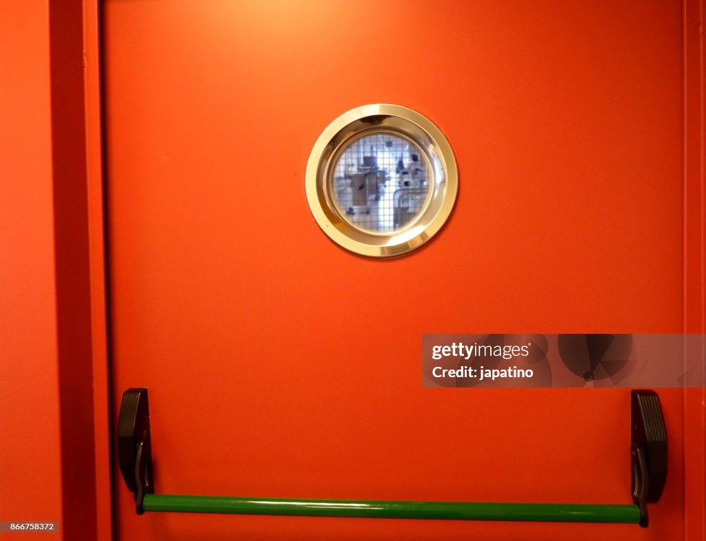Hospital corridor seen through the window of the emmergencia door